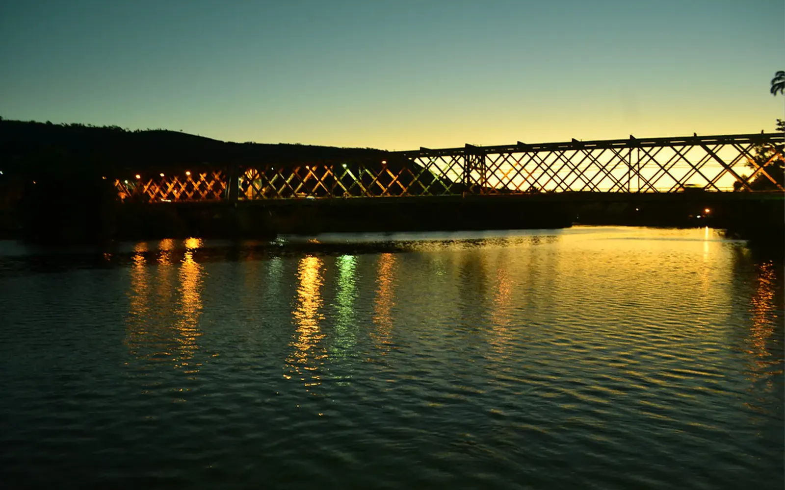 Ponte Dom Pedro II iluminada ao anoitecer, refletida nas águas do Rio Paraguaçu entre Cachoeira e São Félix