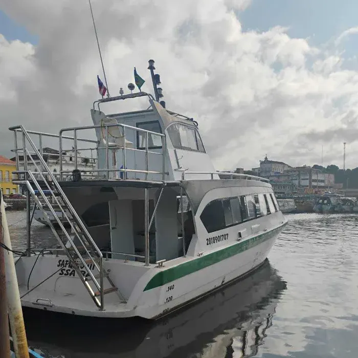 Embarcação branca com faixa verde atracada no Terminal Marítimo de Salvador, pronta para a travessia até Boipeba