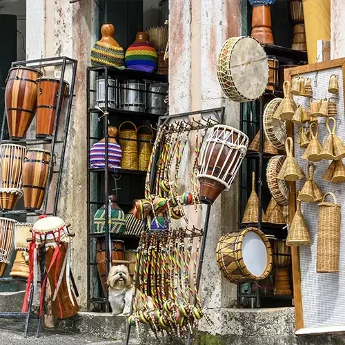 Banca de artesanato do Mercado Modelo, com atabaques, pandeiros, berimbaus e cestaria pendurados