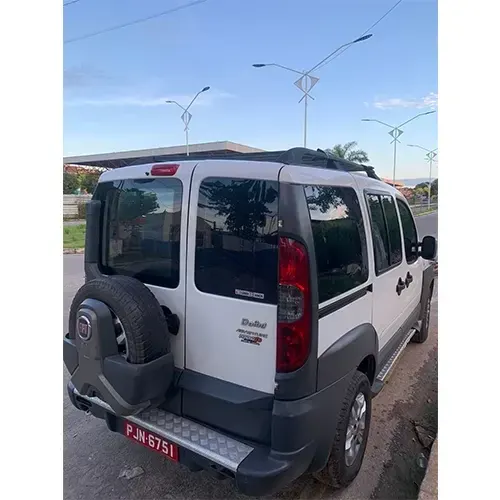Veículo branco de receptivo estacionado na rua, visto de trás